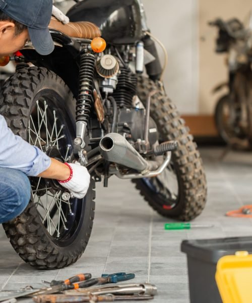 young-man-fixing-motorcycle-workshop-garage-man-repairing-motorcycle-repair-shop-mechanical-hobby-repairs-concepts-min